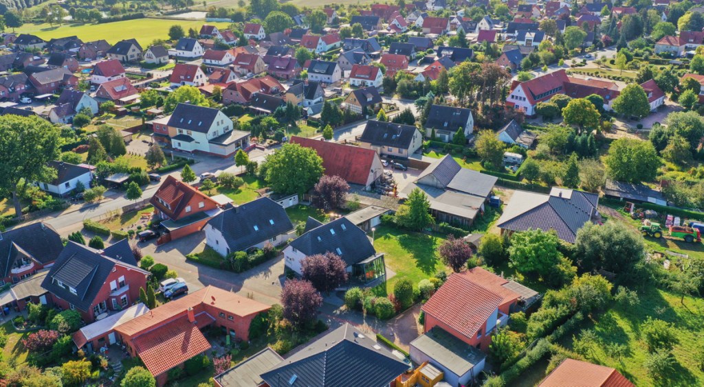 Aerial view of a suburb with detached houses, garden areas, lawns and a close neighbourhood